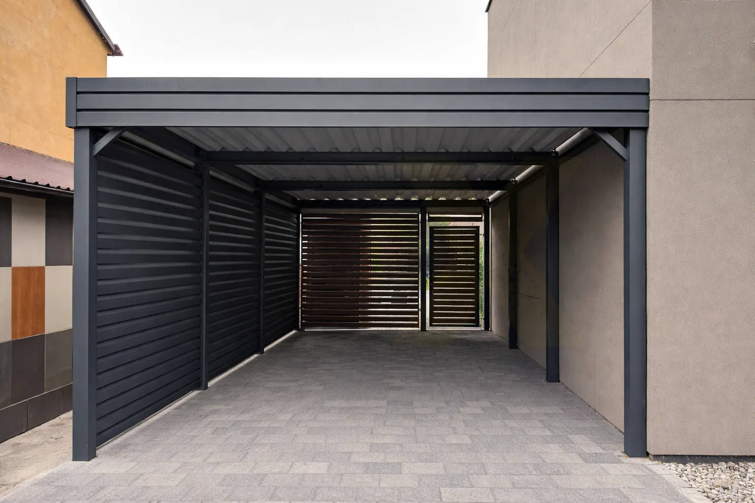 Einzelcarport als Wandanbau mit blickdichten Sichtschutzwänden und Seitenwand