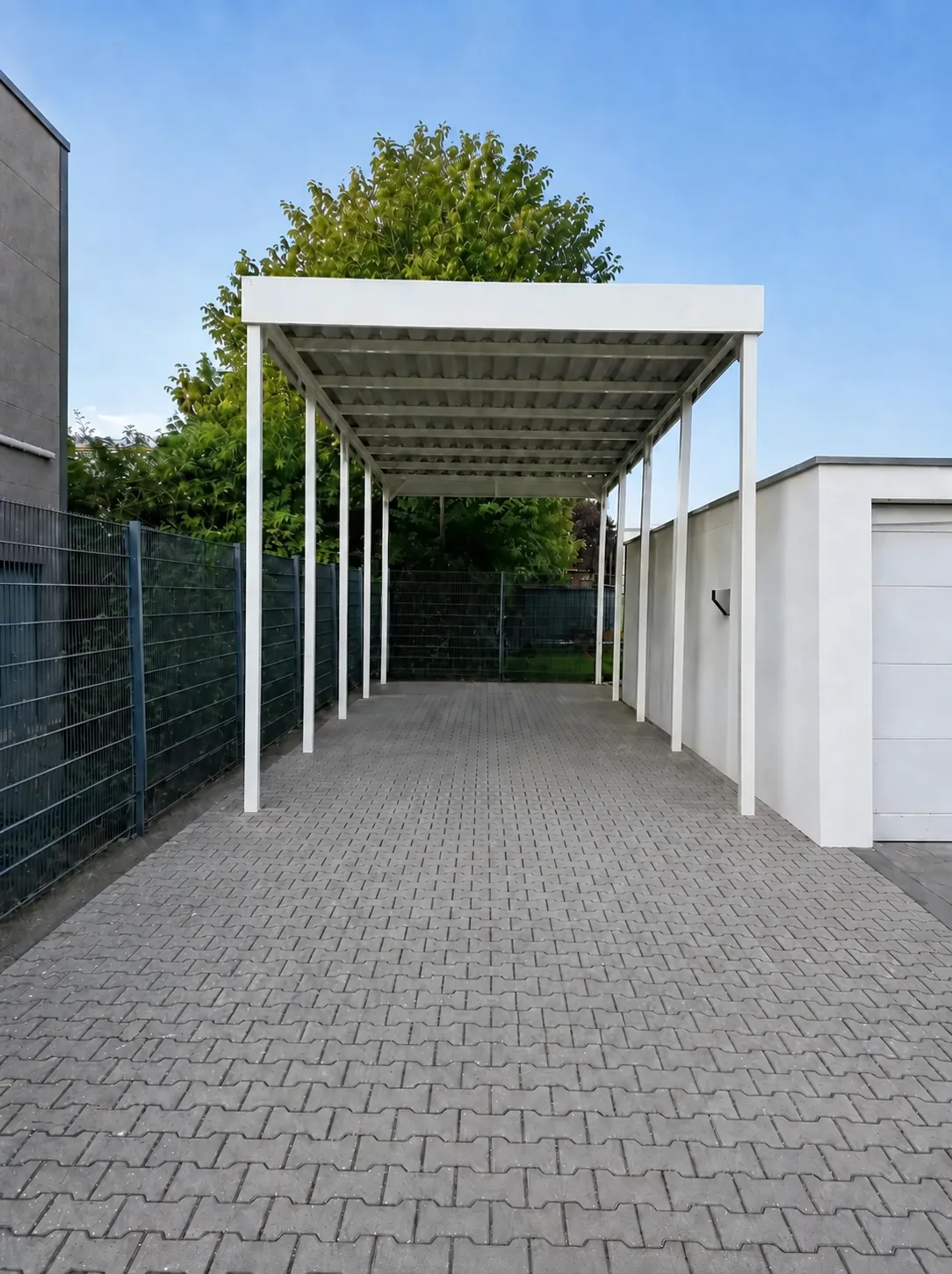 Weißes Wohnmobil mit 4,70 m Länge unter einem Stahlcarport